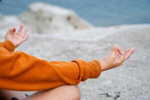 le pose de Bouddha et jnana est sage. yoga, pleine conscience, sagesse. une proche coup de le mains de une la personne Faire yoga. des sports par le mer photo