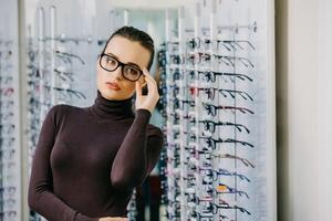 magnifique fille portant des lunettes dans opticien magasin. vue correction. optique. émotions. ophtalmologie. photo