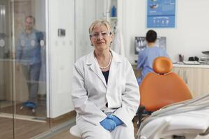 portrait de spécialiste orthodontiste médecin travail dans stomatologique hôpital Bureau pièce attendre pour malade patient à début dent examen. médical équipe travail à soins de santé traitement. médicament prestations de service photo