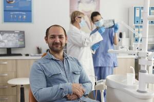 portrait de homme patient avec carie infection séance sur chaise attendre à début médical procédure pendant stomatologique examen dans orthodontique bureau, concept de médicament prestations de service photo