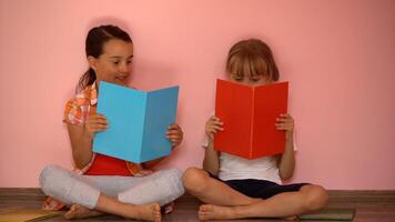 éducation et école concept - peu étudiant les filles en train d'étudier et en train de lire livre à Accueil photo