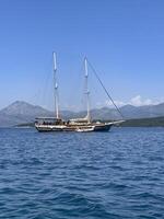 une grand bateau flottant dans le océan avec montagnes dans le Contexte photo