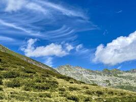 une herbeux colline avec une bleu ciel et des nuages photo