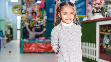 Fillette de 5 ans souriante dans une aire de jeux pour enfants photo