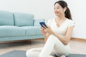 svelte femme utilisation téléphone et ressentir des loisirs sur yoga activité. asiatique femme des exercices dans Matin. équilibre, méditation, relaxation, calme, bien santé, content, se détendre, en bonne santé mode de vie, régime, svelte photo