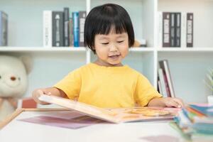 content asiatique les enfants se détendre lis livre à maison. fille et en train de lire une histoire. apprendre développement, garde d'enfants, en riant, éducation, narration, pratique, imaginer, réduire dépendance mobile téléphone photo