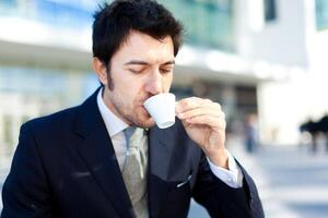 Beau homme d'affaire en buvant café pour petit déjeuner photo