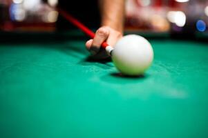 Jeune homme en jouant billard, visée. pour une bien coup photo