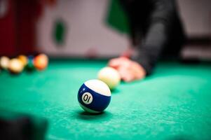 Jeune homme en jouant billard, visée. pour une bien coup photo