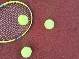 Jaune tennis des balles et raquette sur difficile tennis tribunal surface, Haut vue tennis scène photo