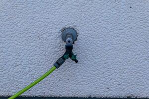 une l'eau robinet lien sur une maison mur photo