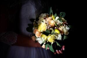 mariage bouquet dans de la mariée mains plus de le foncé Contexte. beauté coloré fleurs pour mariage dans de la mariée mains. fermer photo