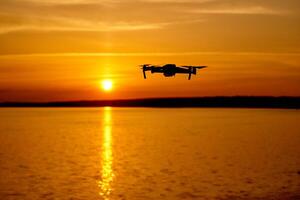 drone en volant à le le coucher du soleil moment. drone quadcopter avec numérique caméra en volant à le coucher du soleil photo