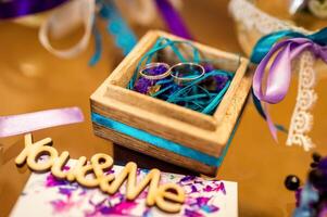 mariage décoration. d'or anneaux dans en bois boîte avec coloré rubans à l'intérieur. photo