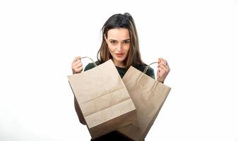 femme est en portant deux épicerie achats Sacs sur blanc Contexte. papier Sacs dans mains. isolé Contexte. photo