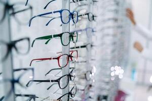 supporter avec des lunettes dans le boutique de optique. une femme main choisit des lunettes photo