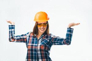 content Jeune fille dans bleu et rouge chemise, des lunettes et Orange protecteur casque. magnifique souriant femme dans bâtiment casque montrant équilibre avec sa mains sur blanc Contexte. photo