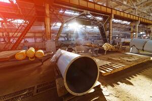 métal tube dans une énorme usine entrepôt avec lumière fuir. équipement à l'intérieur de une moderne industriel Puissance plante. photo