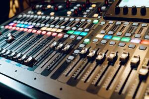 professionnel l'audio mélange console avec faders et ajustement boutons, tv équipement. le dj est ajustement le le volume de le son. photo