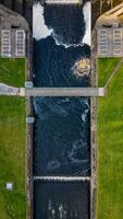 aérien vue de une l'eau canal avec écoulement l'eau et adjacent voies. photo