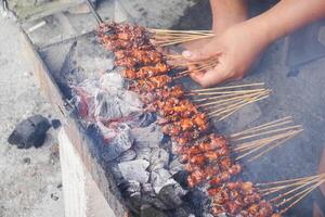 Haut vue de assouvir ou saté, traditionnel nourriture de Indonésie est étant grillé sur ardent charbon. photo