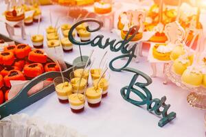 bonbons bar, table avec coloré bonbons, des sucreries, dessert. buffet avec délicieux petits gâteaux, gâteau saute, des biscuits, bonbons. photo