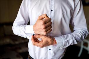 perdre en haut de une homme dans blanc chemise et bouton de manchette. jeune marié séance photo. mariage des photos. photo