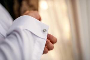 homme d'affaire Robes blanc chemise. jeune marié avoir prêt dans le Matin avant mariage cérémonie. Masculin mains proche en haut photo