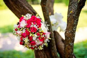 mariage fleurs concept. de la mariée bouquet sur une arbre Contexte. brillant couleurs. fermer. photo
