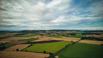 aérien vue de une patchwork de agricole des champs en dessous de une nuageux ciel dans Yorkshire landes. photo