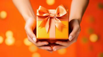 ai généré femme mains tenir un Orange cadeau boîte avec une arc et rubans sur une coloré toile de fond. ai généré photo