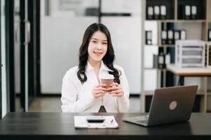 réussi asiatique femme d'affaires en cours d'analyse la finance sur tablette et portable à Bureau bureau impôt, rapport, comptabilité, statistiques, et analytique recherche concept photo