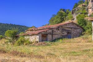 abandonné village maison avec briques des murs et un carrelage rouge toit photo