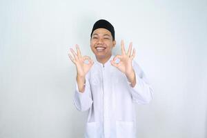 souriant asiatique homme musulman spectacle D'accord panneaux isolé sur blanc Contexte photo