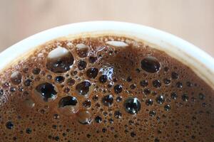 Haut vue de chaud café avec bulle sur blanc Contexte photo