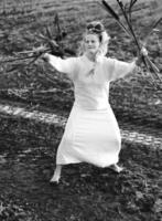 de bonne humeur Jeune femme avec roseaux danses dans coloré fumée dans une champ. photo