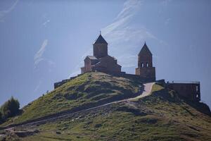 proche vue de saint trinité église dans Kazbegi Montagne intervalle près stepantsminda vue Caucase montagnes dans le Contexte photo