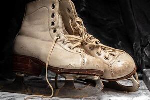 ancien vieux patins minable et usé en dehors sur une neigeux Contexte. photo