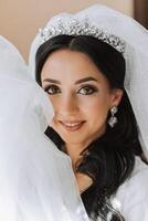 magnifique la mariée dans une pansement robe dans le Matin avant le mariage cérémonie. incroyable coiffure de le la mariée. Naturel et moderne se maquiller. portrait de une Jeune la mariée dans une pansement robe. photo