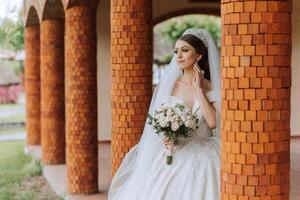 magnifique la mariée avec mariage fleurs bouquet, attrayant femme dans mariage robe. content nouveau marié femme. la mariée avec mariage maquillage et coiffure. souriant la mariée. mariage journée. magnifique la mariée. mariage. photo