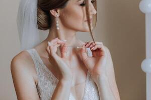 portrait de le la mariée dans le Hôtel chambre. une magnifique Jeune fille est habillé dans une blanc mariage robe. moderne mariage coiffure. Naturel se maquiller. photo