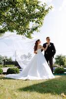 le la mariée et jeune marié embrasser. le la mariée doucement câlins le jeune marié par le épaules. magnifique mariage couple. le concept de romance dans une jeunes mariés relation. voyage de noces. photo