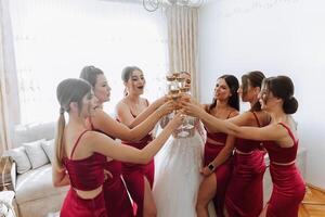 photo la mariée avec sa copains en buvant Champagne de lunettes. tondu coup de une magnifique Jeune la mariée et sa demoiselles d'honneur ayant Champagne avant le mariage.