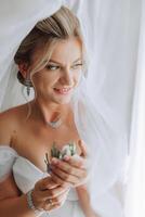 portrait de le la mariée dans le Hôtel chambre. une magnifique Jeune fille est habillé dans une blanc mariage robe. moderne mariage coiffure. Naturel se maquiller. photo