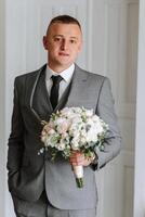 portrait de une Jeune jeune marié à Accueil avant le mariage cérémonie. une Beau homme habillé dans une classique costume. Masculin portrait. photo