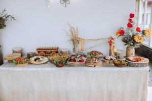Viande et fromage collations sur le buffet. une buffet dans une fermé chambre, à une mariage fête ou anniversaire. des sandwichs sur brochettes avant le début de le vacances. photo