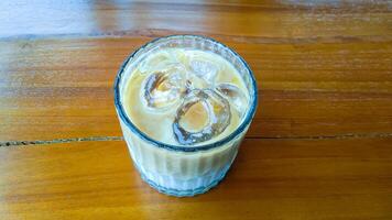 une verre de du froid cappuccino sur une en bois table photo