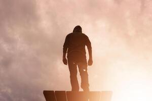 homme silhouette à la recherche à le magnifique le coucher du soleil dans heure d'été photo