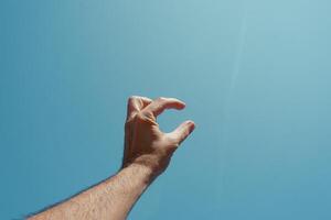 homme main faire des gestes et atteindre le bleu ciel photo