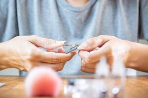 femme mains à propos à Couper sa longue Naturel ongles avec pinces. photo